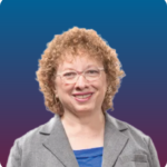 Headshot of Joyce Bender, a white woman with short, curly blonde hair and wearing glasses.